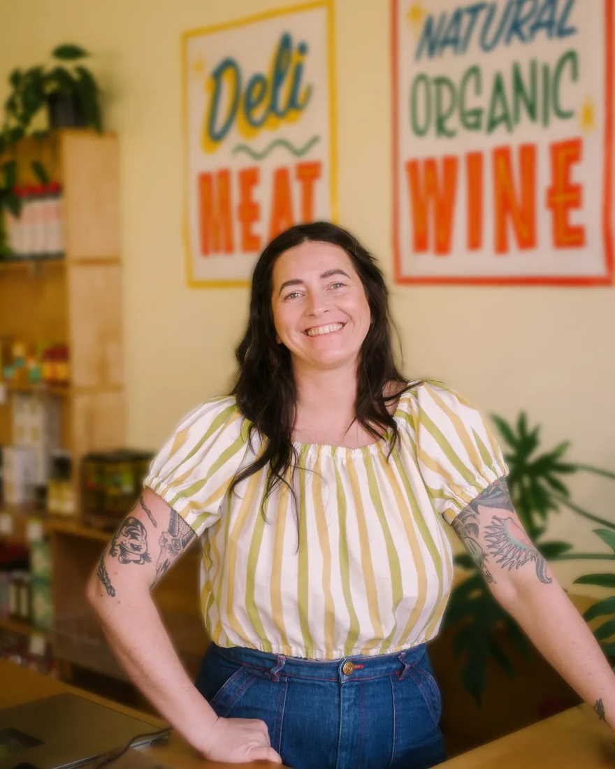 Owner behind the counter of a local deli and wine shop