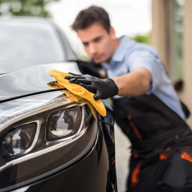 Mobile detailer polishing a car
