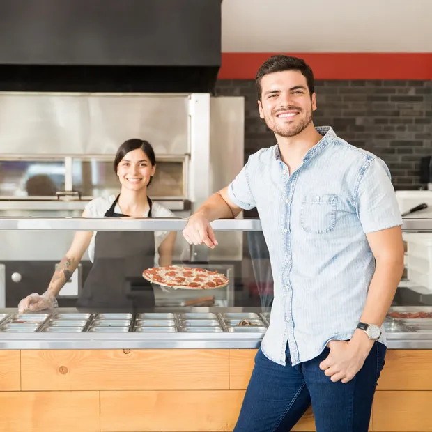 Restaurant owner serving a fresh pizza
